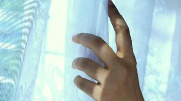 A person is reaching out to the window to open it video