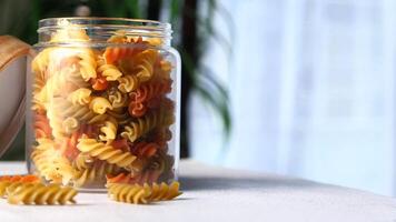 A jar of pasta is sitting on a table next to a plant video