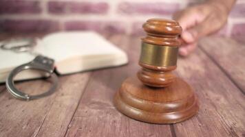 A judge's gavel on a wooden table with a pen and a key video