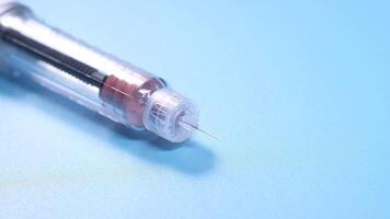 A syringe with a needle on a blue surface video