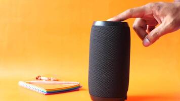 A person is holding a speaker next to a notebook video