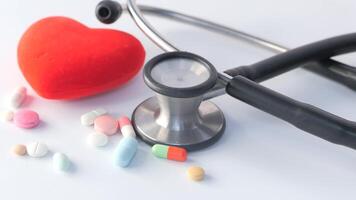 A stethoscope and a heart shaped pill on a white surface video
