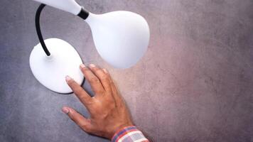 A person touching a lamp on a table video