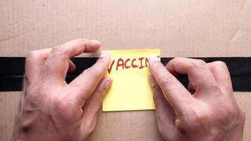 A person holding a sticky note with the word vaccin on it video