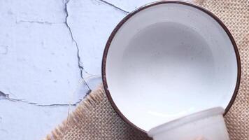A white bowl with a brown handle sitting on a table video