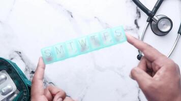 A person holding a pill with a stethoscope next to it video
