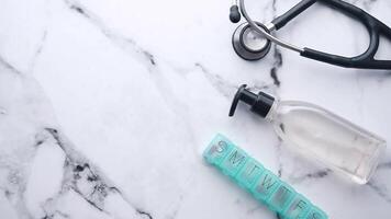 A bottle of hand sanitizer, a stethoscope and a bottle of pills video