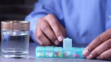 A man is holding a pill box with pills in it video