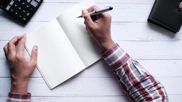 Man writing in notebook on desk video