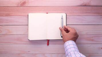 Hand writing in notebook on wooden table video