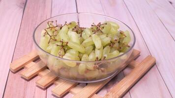 A bowl of green grapes on a wooden table video