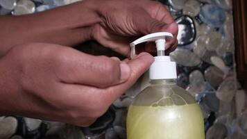 A person is using a bottle of soap to clean their hands video