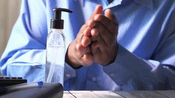A man is clapping his hands while holding a bottle of hand sanitizer video