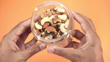 A person holding a container of nuts and dried fruit video