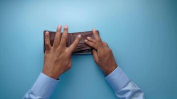 A person holding an empty wallet on a blue background video