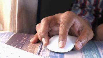 A person's hand on a mouse with a keyboard video