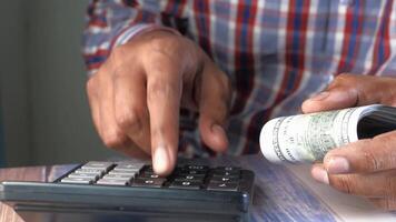 A man is using a calculator to pay for his purchase video