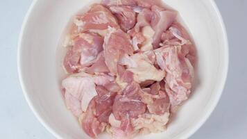 Raw chicken in a bowl on a white surface video