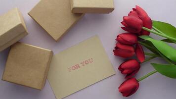 A bouquet of red tulips and a card with a message video