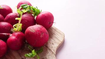 Fresh radishes on a wooden cutting board video