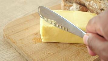 closeup of cutting a butter with a knife on a chopping board video