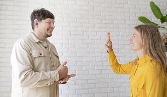 young woman and deaf man with audiology implant, service or help for sound waves photo