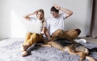 young woman and deaf man with audiology implant, having online call on laptop and gesturing photo