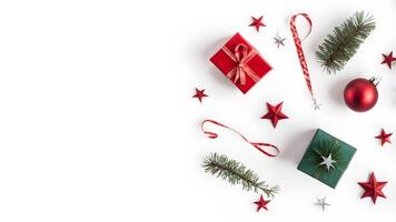 Top view layout with left blank space adorned pine tree branch, red ball, gift box, ribbon and star on white background like snow photo