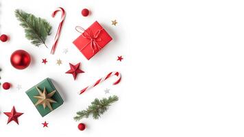 Top view layout with right blank space adorned red and green gift box, shiny balls, star, pine tree branch, candy cane on white background like snow photo