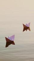 Three white paper ships floating in the river at sunset. Small childish paper boats swim in the lake with their reflection in the calm water. Vertical video