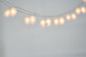 View of string light in the shape of pinecone lights background with copy space. Christmas garlands and lights decoration. Selective focus photo
