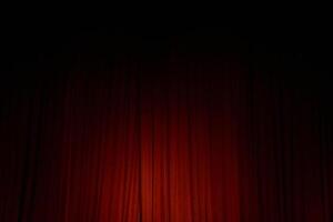 Spot light on the red closed curtain or drapes on stage in theater with copy space. Theatrical performance concept photo