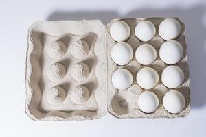 Chicken white eggs in a carton box on a white background. photo
