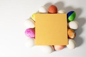 Colorful easter eggs with yellow card on a white background. photo