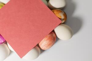 Colorful easter eggs with red blank card on white background photo