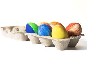 Happy Easter. Colorful easter eggs in egg carton isolated on white background. photo