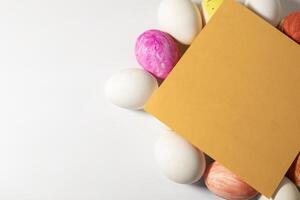 Colorful Easter eggs with blank card on white background photo