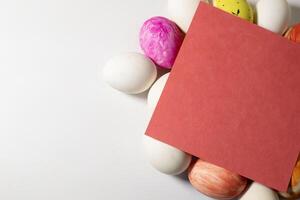 Easter eggs with blank red card on white background photo