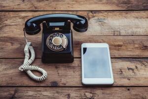 Old rotary phone and new smartphone showing technological evolution on desk photo