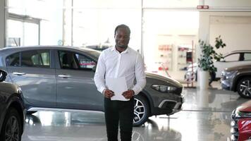 Salesman walking in a car dealership and checks the availability of cars video
