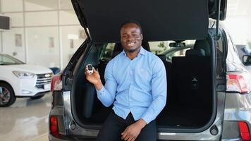 Happy african american man showing the key of his new car video