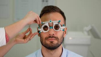 Optometrist or ophthalmologist uses phoropter ocular device tool to measure vision diopters of a man with retina defects video