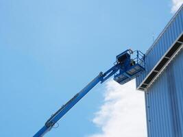Using a boom truck to work on the roof of a tall building photo