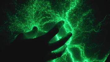 Hand touch plasma ball, creating vibrant green lightning patterns. Static electricity model on science exhibit video