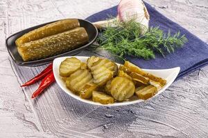 Sliced marinated cucumbers in the bowl photo