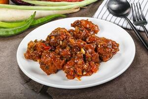 Manchurian chicken with sauce and spices photo