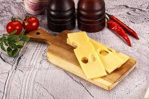 Maasdam cheese piece with slices photo