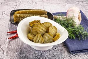Sliced marinated cucumbers in the bowl photo