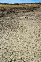 Cracked red clay and white salt on the surface in a dried riverbed in the desert of New Mexico, USA photo