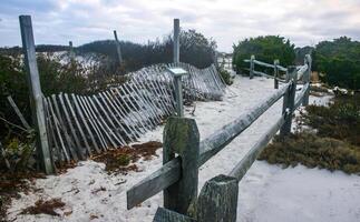 New Jersey, USA - November 19, 2009 a path with a wooden fence on the sand along protected dunes on the ocean shore, NJ photo